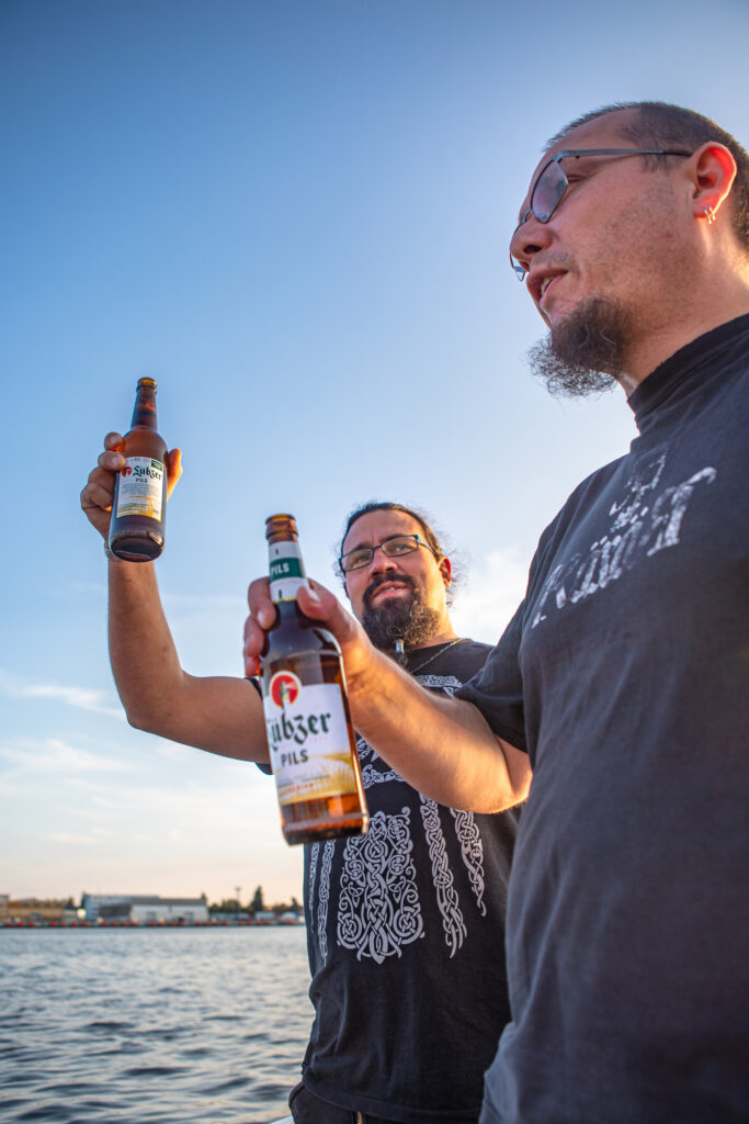 DJ Jiří & DJ Ewi stoßen an mit Flaschenbier.